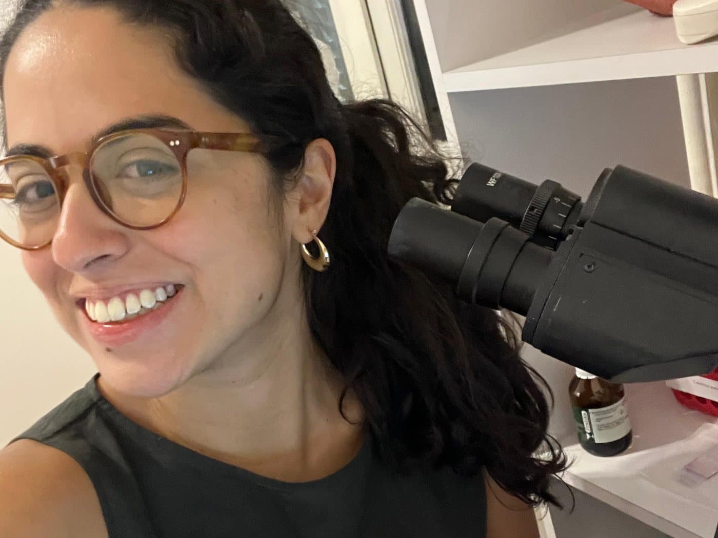 Dra. Gabriela Giannini ao lado do microscópio em que analisa as lâminas